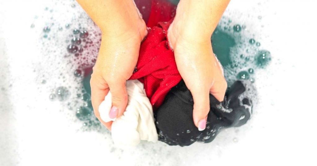 Hand washing clothes in sink